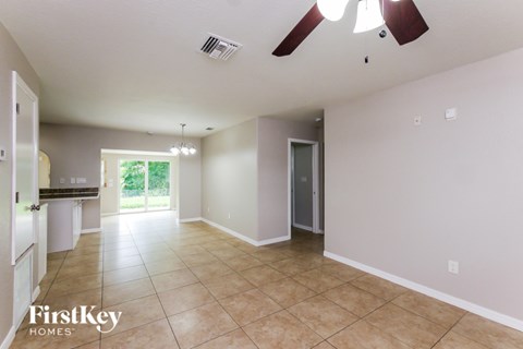 A spacious room with a ceiling fan and a door leading to a balcony.