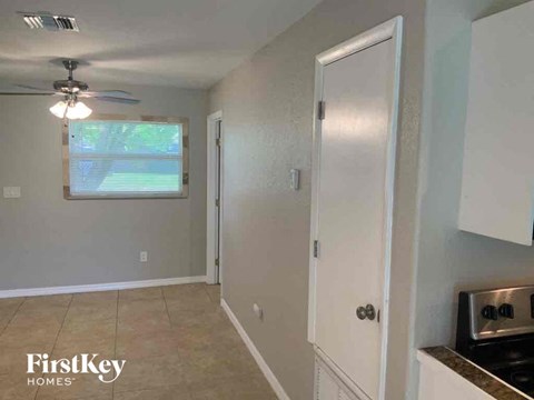 A kitchen area with a stove top oven and a door leading to another room.