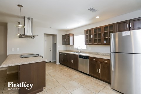 A kitchen with a stainless steel refrigerator and wooden cabinets.