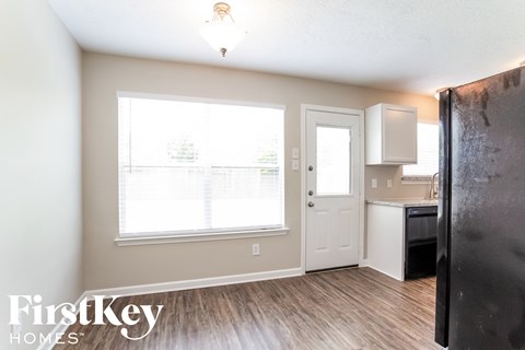 a kitchen with a refrigerator and a window and a door