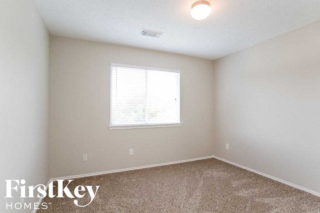 a bedroom with a carpeted floor and a window