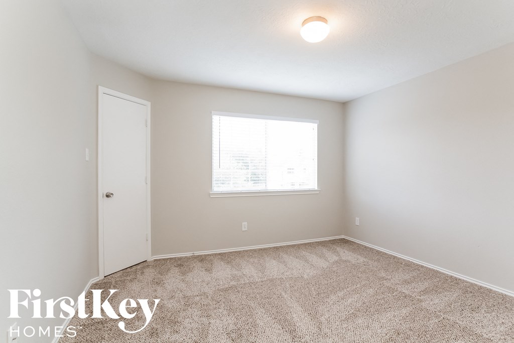 a bedroom with carpeted flooring and a window