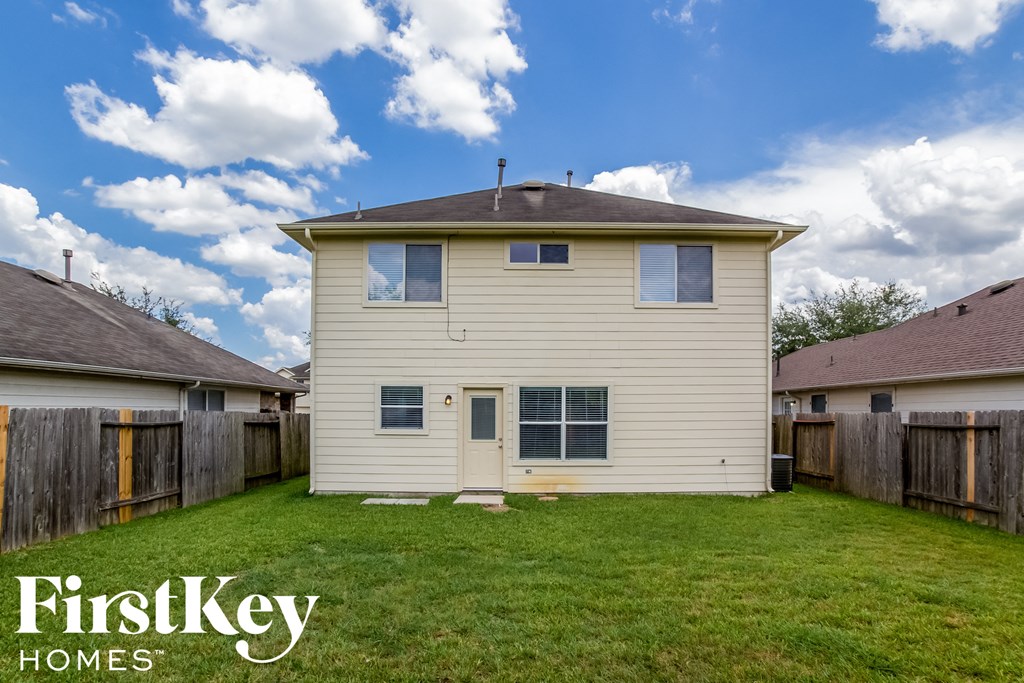 the backyard of a house with a lawn and a wooden fence