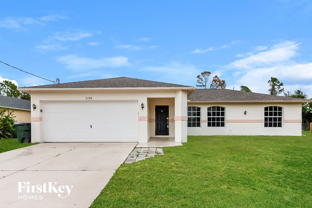 A white house with a black door and windows is for sale.