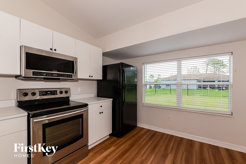 A kitchen with a stove, oven, refrigerator, and microwave.