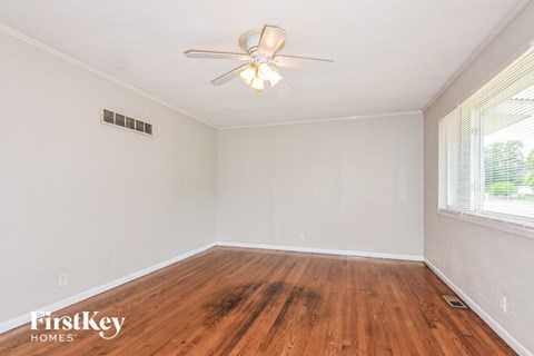 a living room with wood floors and a ceiling fan