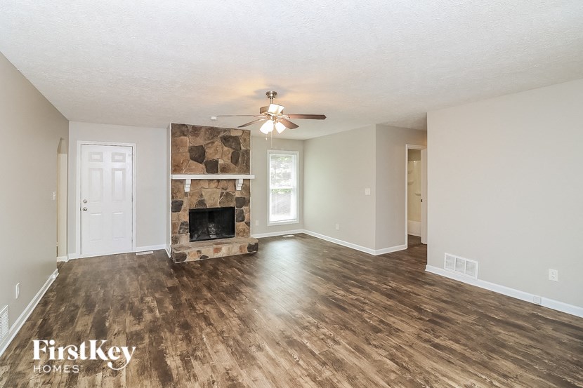 a living room with a fireplace and a ceiling fan