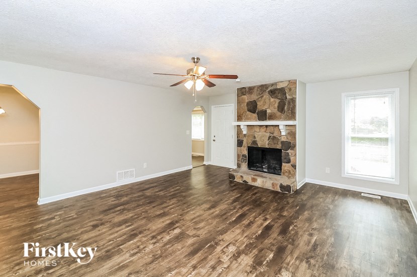 a living room with a fireplace and a ceiling fan