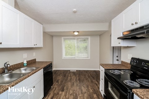 a kitchen with white cabinets and a stove and a sink