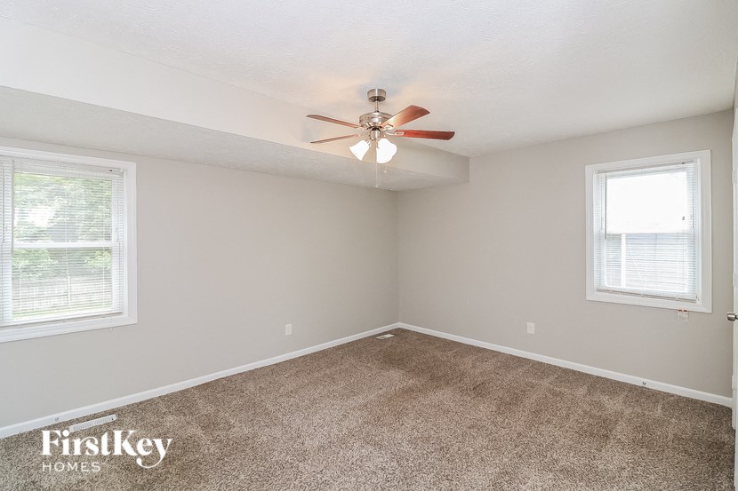 a bedroom with carpet and a ceiling fan