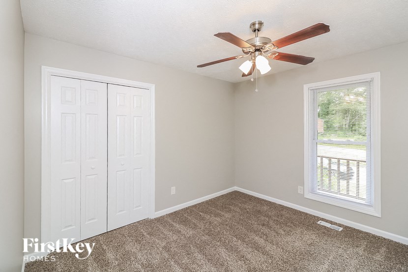 a bedroom with a ceiling fan and a window