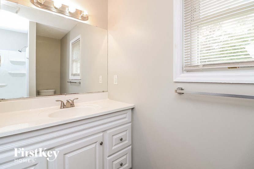 a bathroom with a sink and a mirror and a window