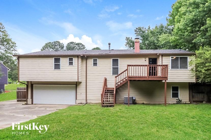the front of a house with a yard and a deck