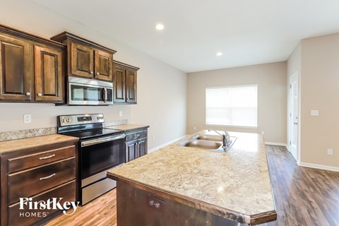 A kitchen with wooden cabinets and a granite countertop.