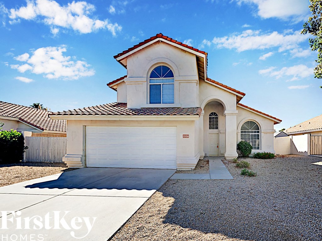 a white house with a white garage door and a driveway