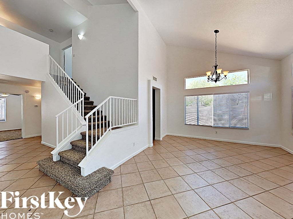 the entryway of a home with a staircase and tile flooring