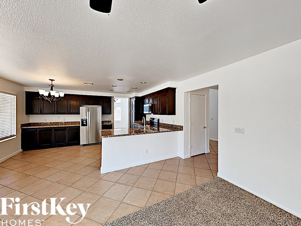 a large kitchen with a counter top and a refrigerator