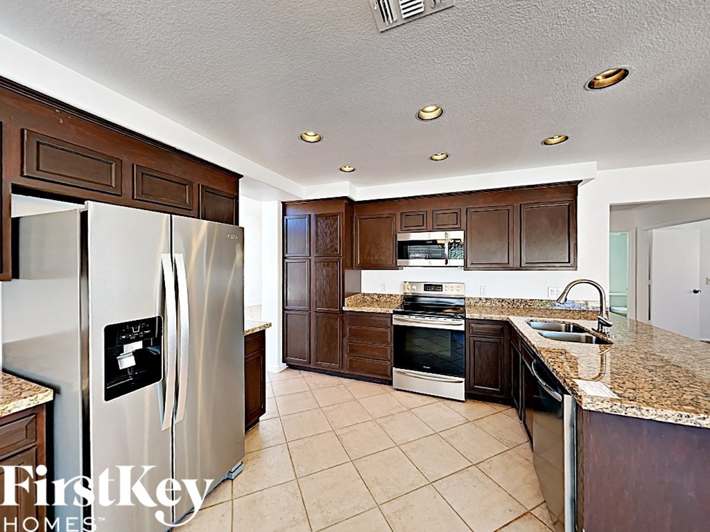 a large kitchen with stainless steel appliances and granite counter tops