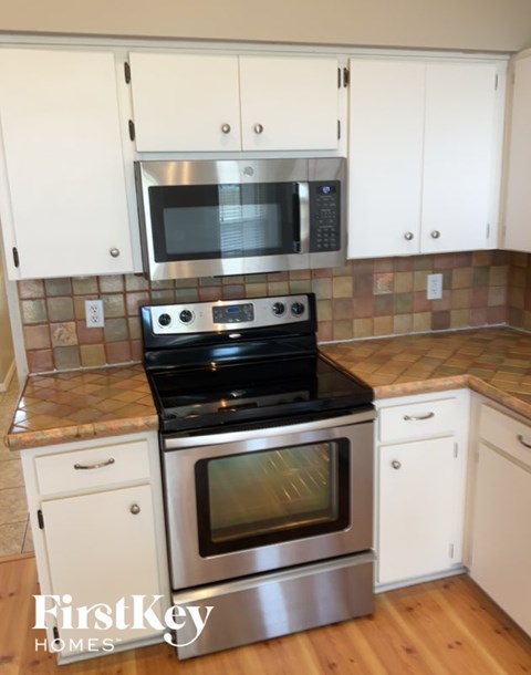 A kitchen with a stove top oven and microwave above it.