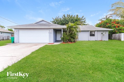 a white house with a lawn and a driveway
