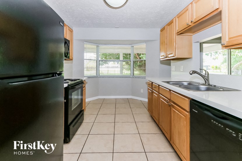 a kitchen with black appliances and wooden cabinets