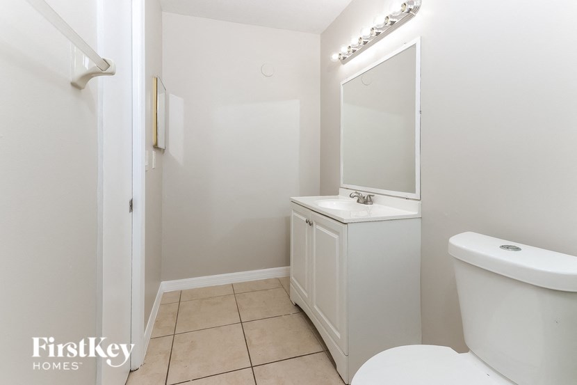 a bathroom with a toilet and a sink and a mirror