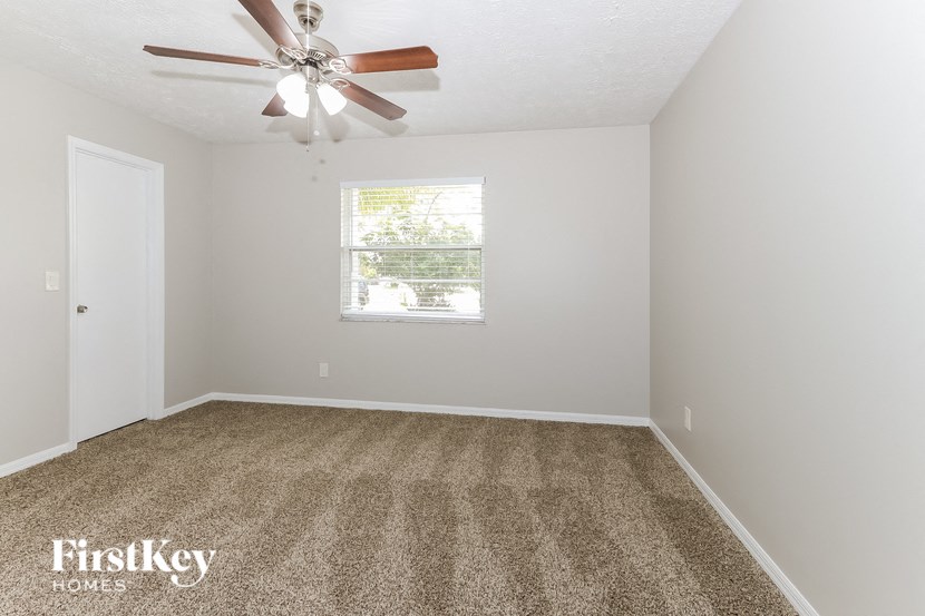 a empty room with a ceiling fan and a window