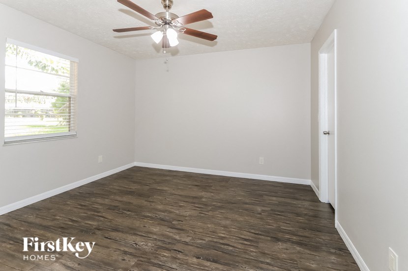 an empty room with a ceiling fan and a window