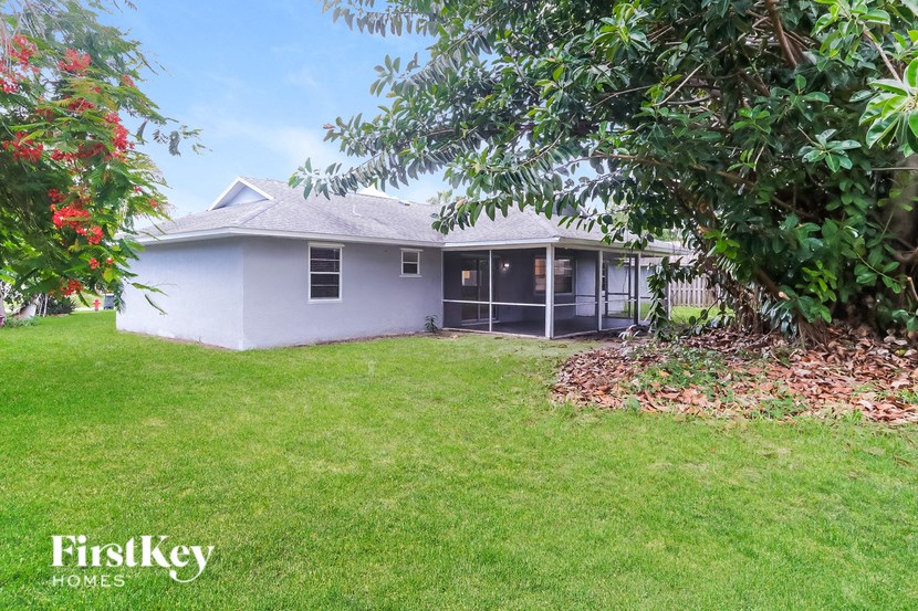 a white house with a yard and trees