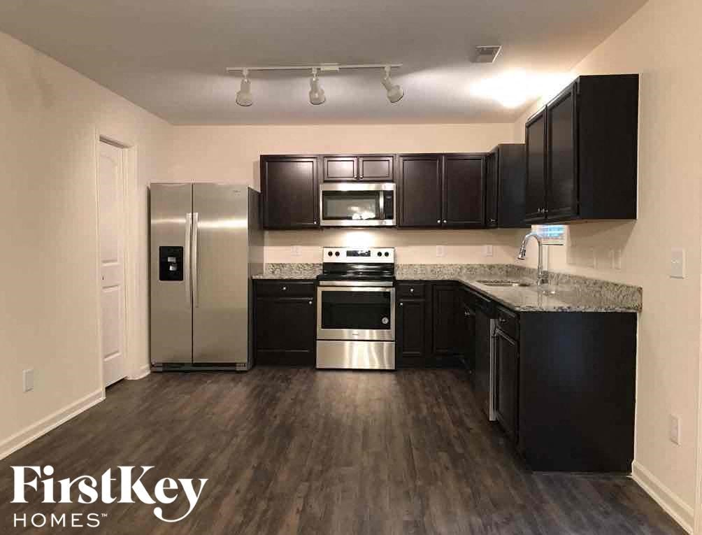 A kitchen with black cabinets and stainless steel appliances.