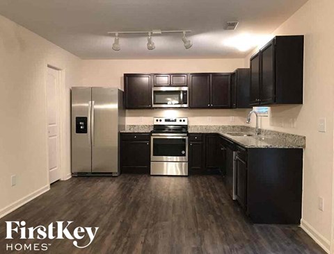 A kitchen with black cabinets and stainless steel appliances.