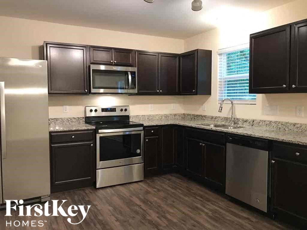 A kitchen with dark wood cabinets and stainless steel appliances.