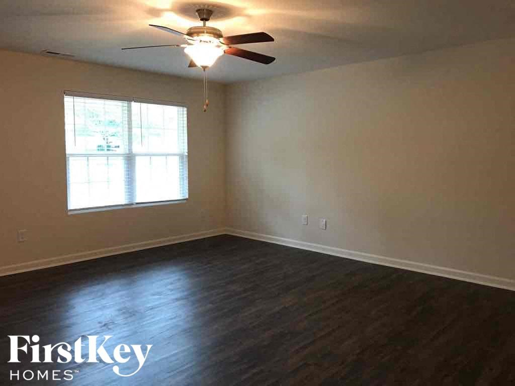 A room with a ceiling fan and a window.