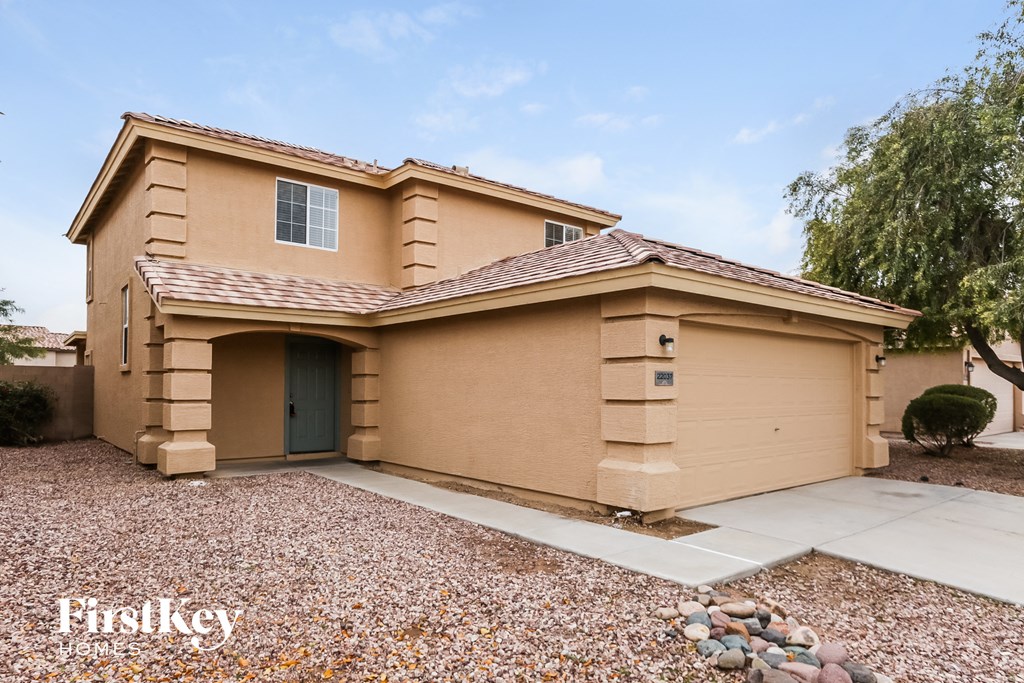 a beige house with a driveway and a garage door