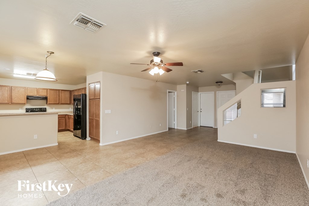 an empty kitchen and living room with a ceiling fan