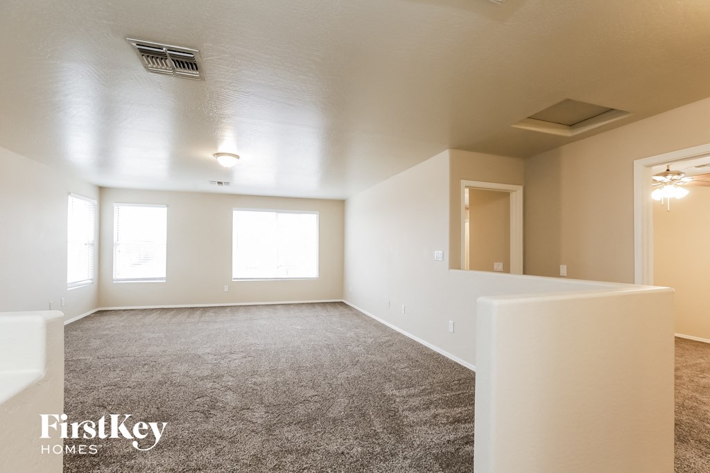 an empty living room with carpet and a window