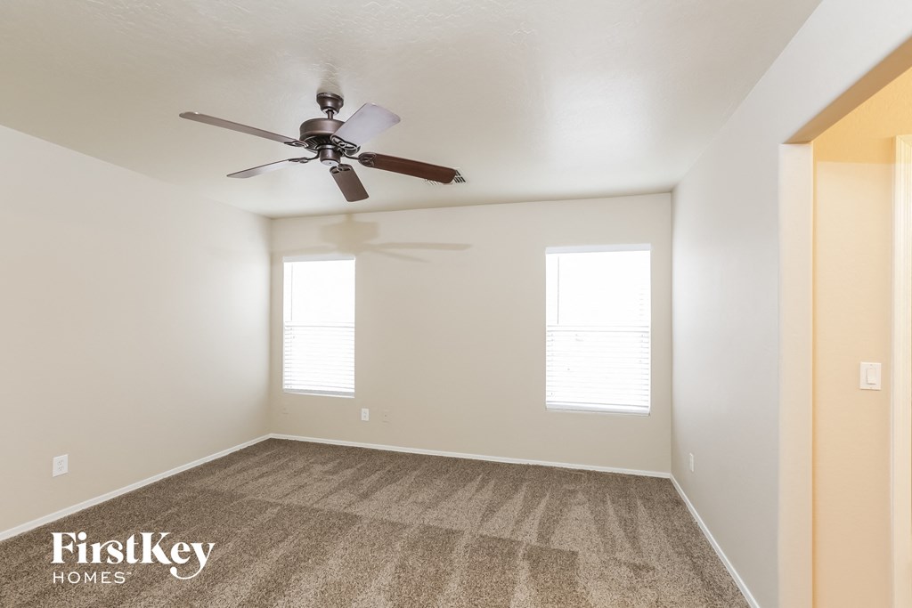 a room with a ceiling fan and a carpet