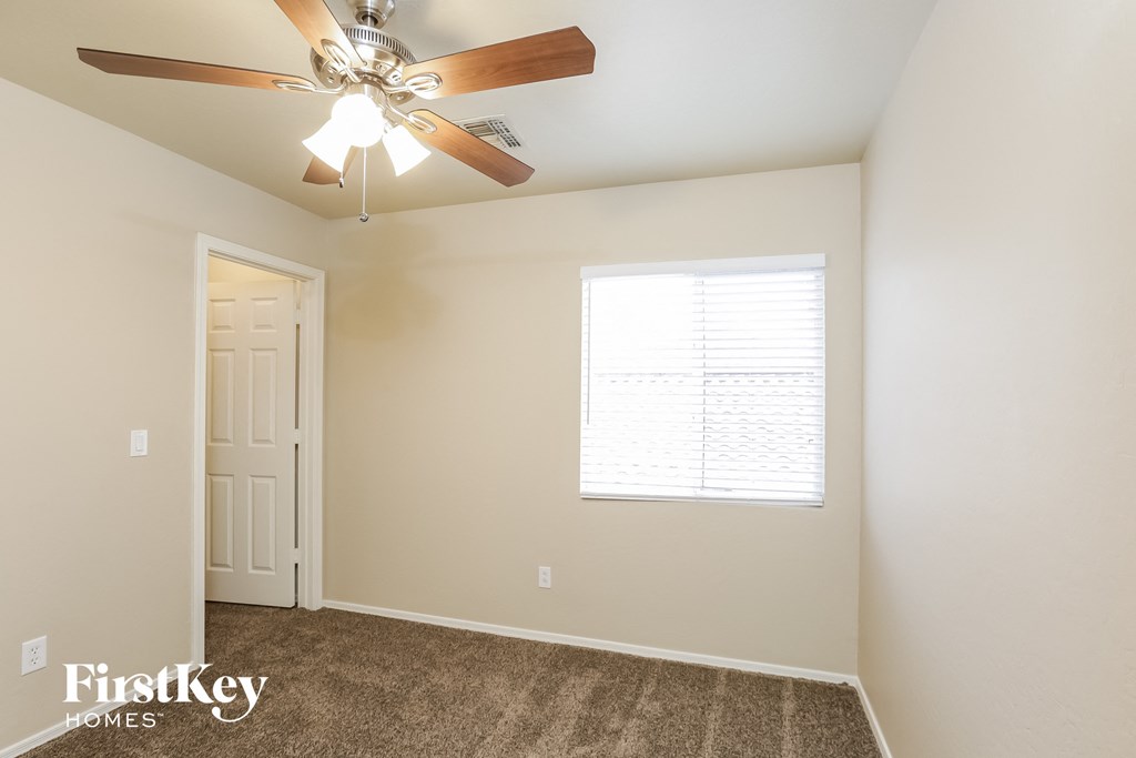 a bedroom with a ceiling fan and a white door