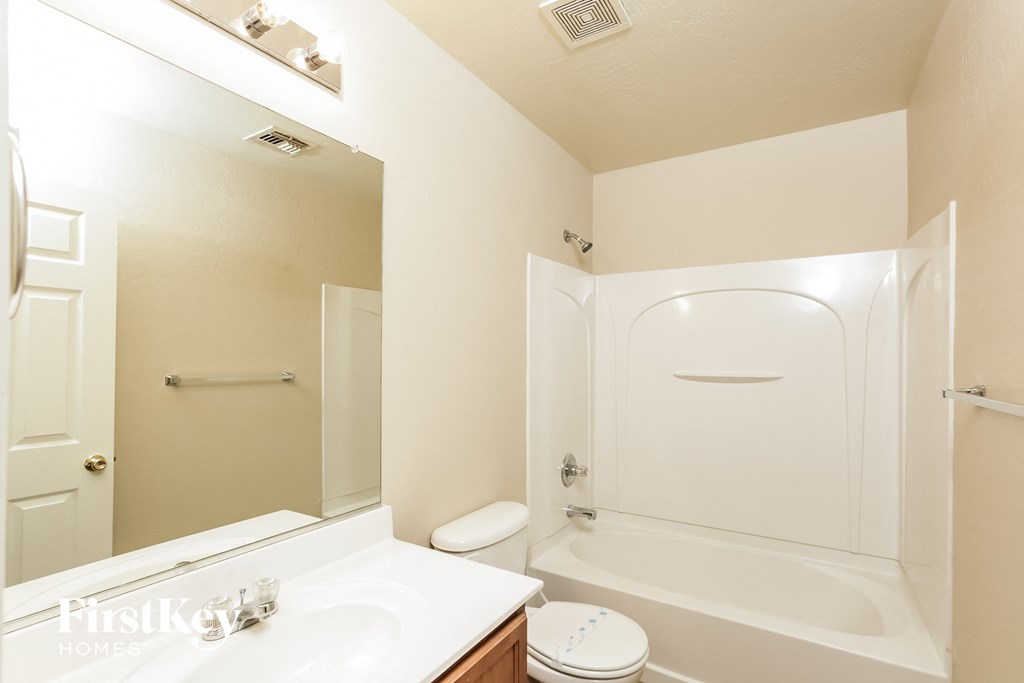 a bathroom with a white toilet and a tub and a sink