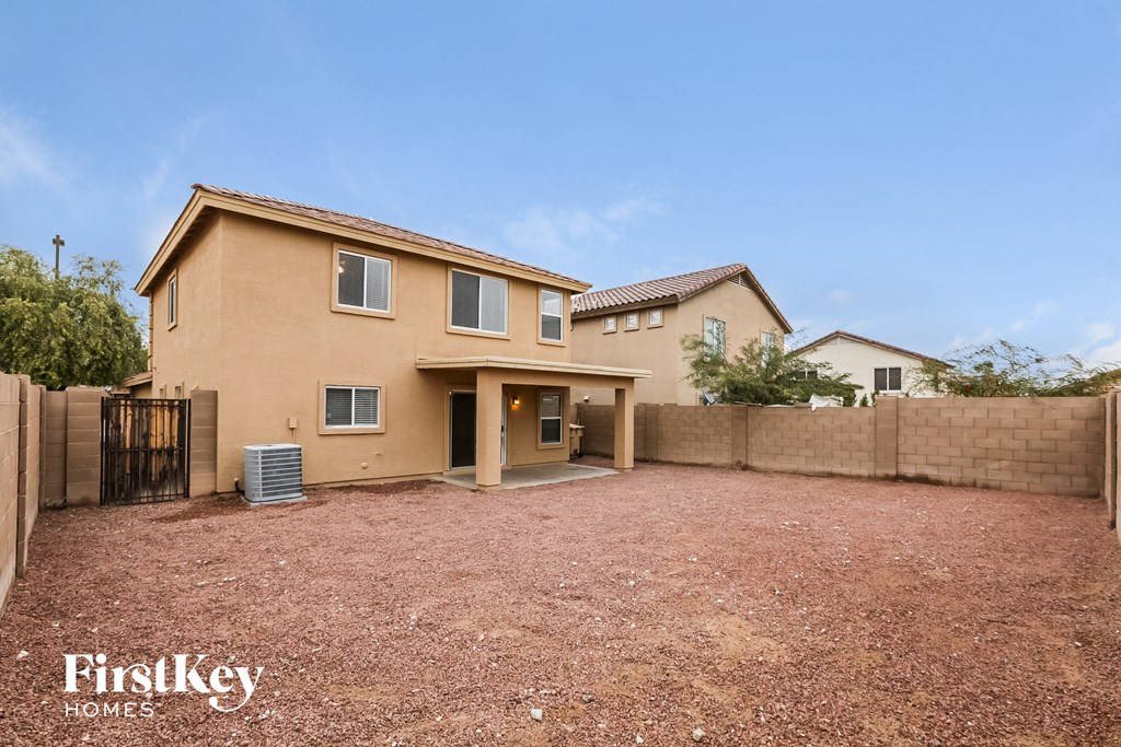 a house with a dirt driveway and a fence
