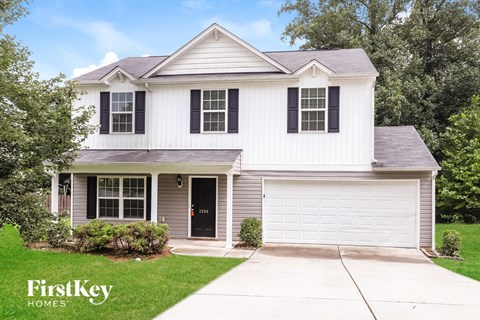 A white house with a black door and a garage door.
