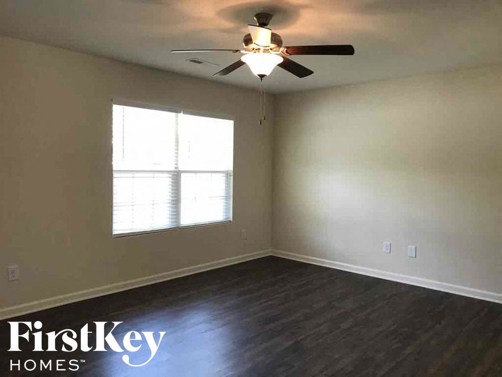 A room with a ceiling fan and a window.