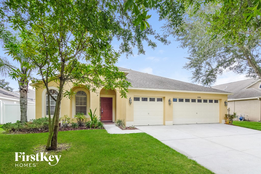 A house with a red door and a tree in front of it.