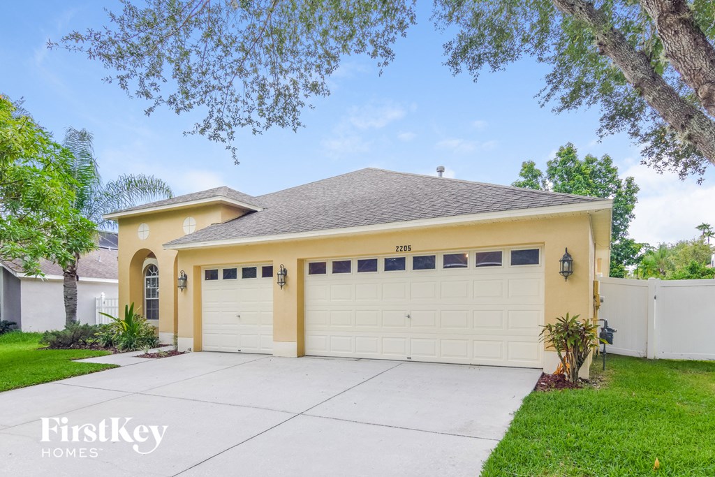 A two-car garage with a white door is attached to a house.