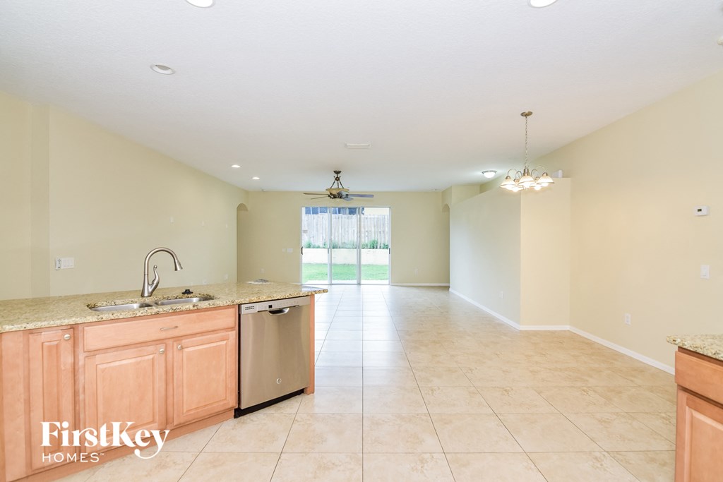A kitchen with a sink, dishwasher, and a window.