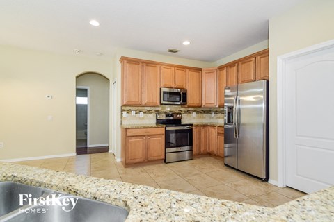 A kitchen with wooden cabinets and a granite countertop.