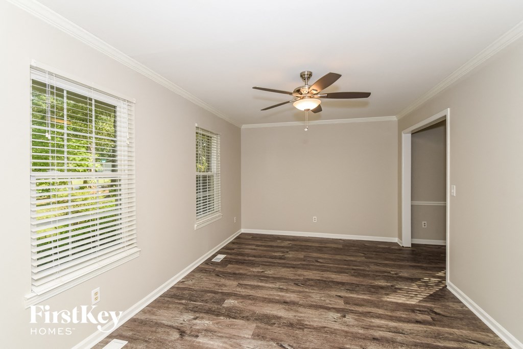 a living room with a large window and a ceiling fan