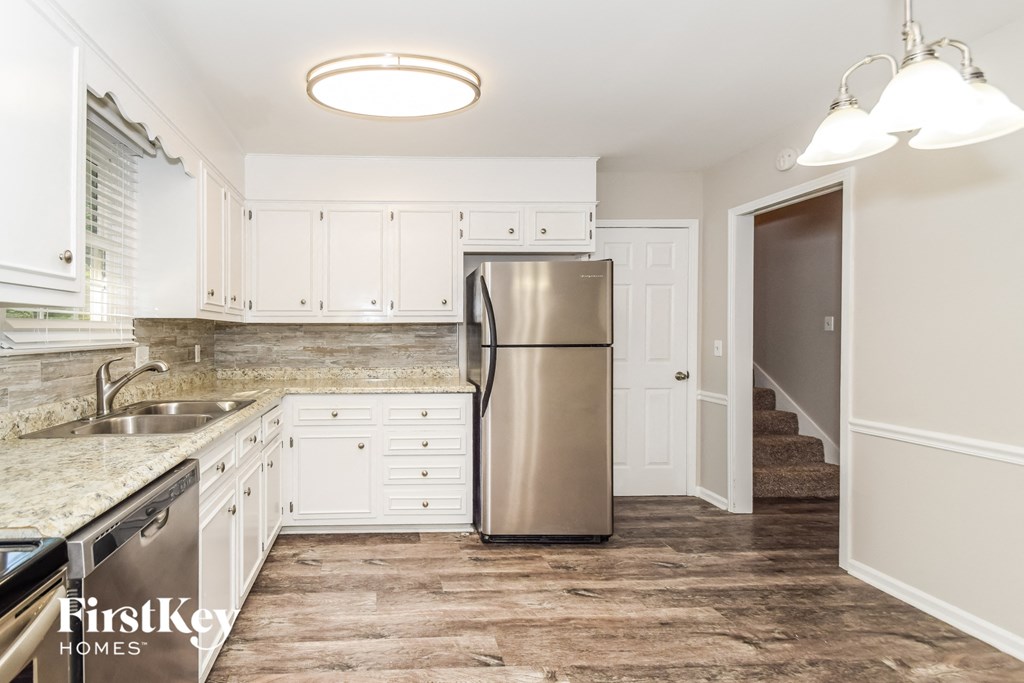 a kitchen with white cabinets and a stainless steel refrigerator