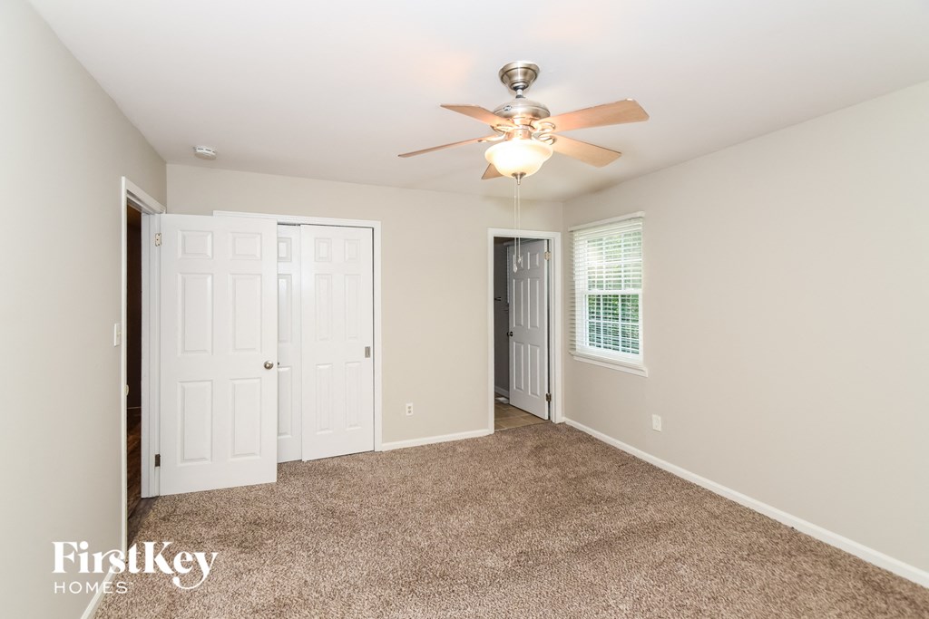 a living room with carpet and a ceiling fan