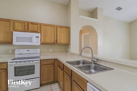 a kitchen with a sink and a stove and a microwave